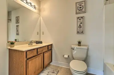 a bathroom with a toilet and a sink and a mirror at New ! Slopeside Townhome : WFH, Ski, Dine & Hike in Tannersville
