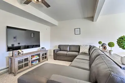 a living room with a couch and a flat screen tv at New ! Slopeside Townhome : WFH, Ski, Dine & Hike in Tannersville