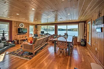 a living room with a table and chairs and a television at BBQ Ready Lakeside Milford Home with Paddleboat in Milford