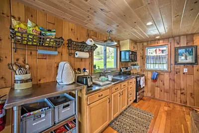 a kitchen with wooden walls and a wooden floor at BBQ Ready Lakeside Milford Home with Paddleboat in Milford