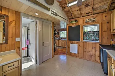 a kitchen with wood paneled walls and a door at BBQ Ready Lakeside Milford Home with Paddleboat in Milford