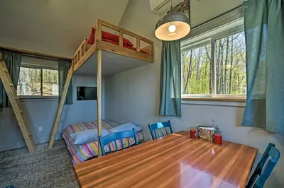 a bedroom with a bunk bed and a table and a bed at Fire Pit and Gas Grill Secluded Studio in Milford! in Milford