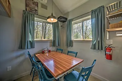 a dining room with a wooden table and chairs at Fire Pit and Gas Grill Secluded Studio in Milford! in Milford
