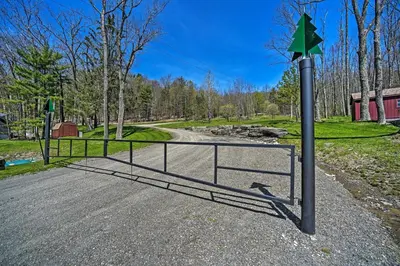 a gate with a green arrow on it next to a road at Fire Pit and Gas Grill Secluded Studio in Milford! in Milford