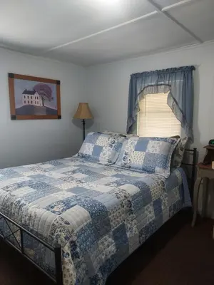 a bedroom with a bed with a blue and white blanket at Serenity Motel in Shaftsbury