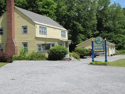 a sign in front of a house with a clock at Serenity Motel in Shaftsbury
