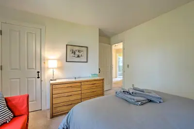 a bedroom with a bed and a dresser and a red chair at Chic Dover Home with Hot Tub 1 Mi to Golf! in West Dover