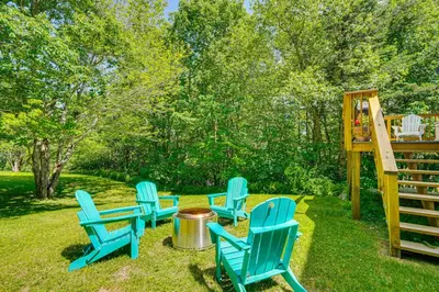 a group of blue chairs sitting in the grass at Chic Dover Home with Hot Tub 1 Mi to Golf! in West Dover