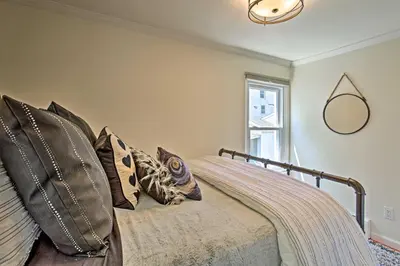 a bedroom with a bed with pillows and a mirror at Updated Home with Patio Half Mile to West Point in Highland Falls