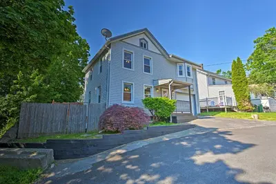 a blue house with a fence in front of it at Updated Home with Patio Half Mile to West Point in Highland Falls