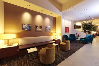 a lobby with a couch and some chairs and tables at Hyatt Place Flushing/LGA Airport in Queens