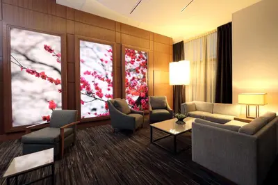 a living room with couches and chairs and a large window at Hyatt Place Flushing/LGA Airport in Queens
