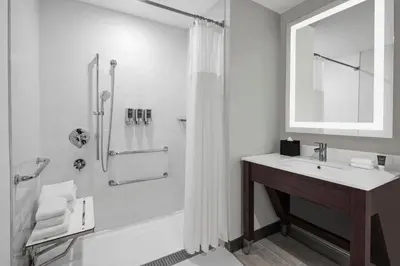 a white bathroom with a shower and a sink at Four Points by Sheraton Flushing in Queens