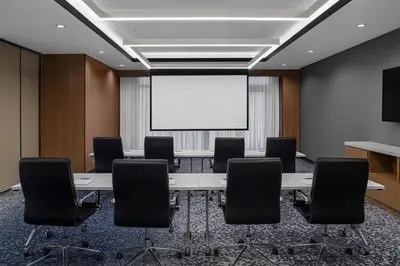 a conference room with a table and chairs and a whiteboard at Four Points by Sheraton Flushing in Queens