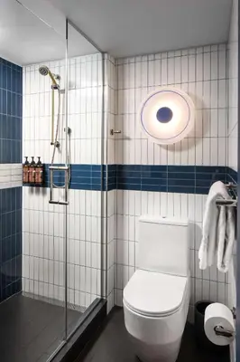 a bathroom with a shower and a toilet in it at Motto by Hilton New York City Chelsea in New York