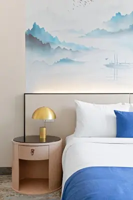 a bedroom with a bed and a table with a lamp at The Parc Hotel in Queens