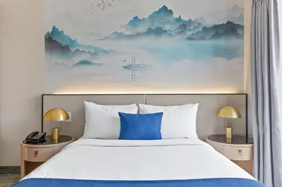 a bedroom with a large bed with blue pillows at The Parc Hotel in Queens