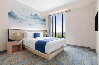 a bedroom with a large bed and a large window at The Parc Hotel in Queens