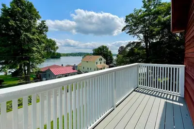 a white balcony with a view of the water at Lakeside Berkshires Home Near Hiking and Skiing! in Lanesborough