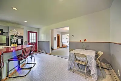 a kitchen with a bar and a table and chairs at Lakeside Berkshires Home Near Hiking and Skiing! in Lanesborough