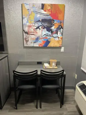 a table with two chairs and a painting on the wall at The Wayne Inn in Wayne