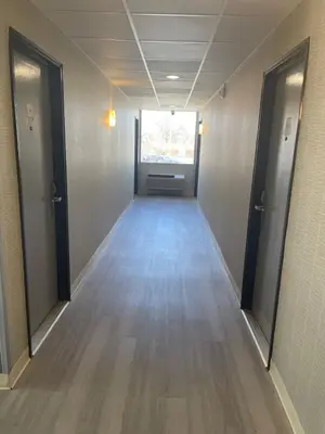 an empty hallway with two doors and a window at The Wayne Inn in Wayne