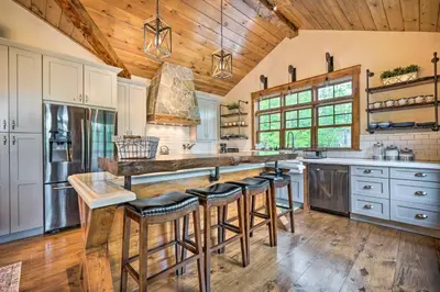 a kitchen with white cabinets and a wooden ceiling at Elegant Mtn Chalet with Deck 1 Mi to Mt Snow! in Dover