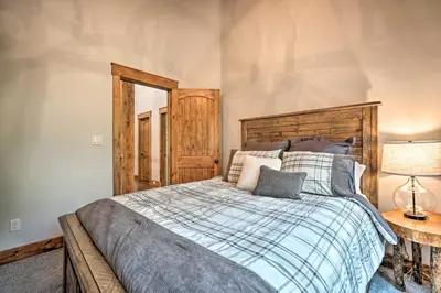 a bedroom with a large bed with a wooden headboard at Elegant Mtn Chalet with Deck 1 Mi to Mt Snow! in Dover