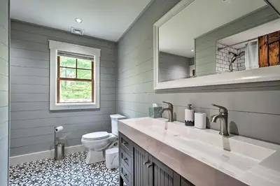 a bathroom with a toilet and a sink and a mirror at Elegant Mtn Chalet with Deck 1 Mi to Mt Snow! in Dover