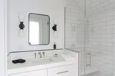 a white bathroom with a sink and a mirror at The Amelia in Hudson