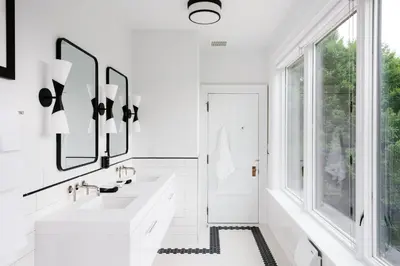 a white bathroom with two sinks and a window at The Amelia in Hudson