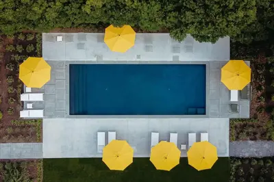 an overhead view of a swimming pool with yellow umbrellas at The Amelia in Hudson