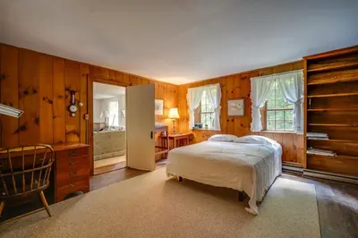 a bedroom with wooden walls and a bed and a chair at Sky Parlor Farm on 480 Acres with Fire Pit! in Salem