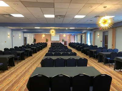 a room with rows of tables and chairs at Albany Airport Inn in Albany