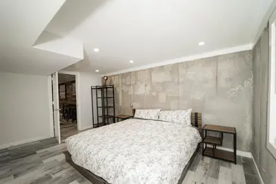a bedroom with a large bed and a wooden floor at Modern home with a private Heated pool and jacuzzi in Hamden