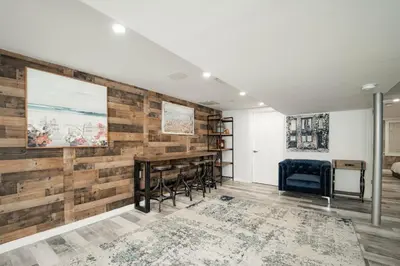 a living room with a reclaimed wood wall at Modern home with a private Heated pool and jacuzzi in Hamden