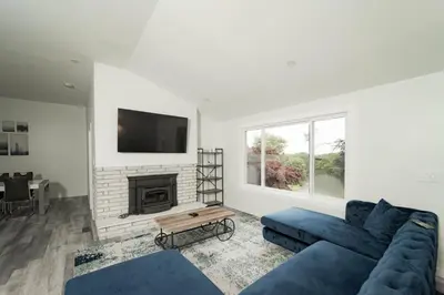 a living room with a blue couch and a fireplace at Modern home with a private Heated pool and jacuzzi in Hamden