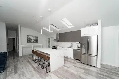 a kitchen with a table and a refrigerator at Modern home with a private Heated pool and jacuzzi in Hamden