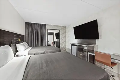 a hotel room with two beds and a flat screen tv at Casa Azul Hotel Blu-UBS Arena in Queens