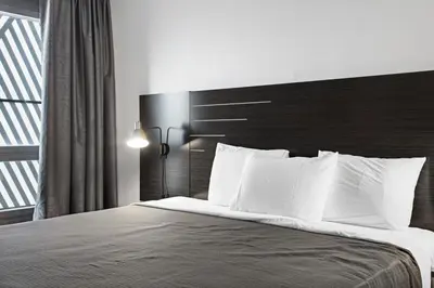 a bedroom with a large bed with white pillows at Casa Azul Hotel Blu-UBS Arena in Queens
