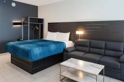 a hotel room with a bed and a couch at Casa Azul Hotel Blu-UBS Arena in Queens