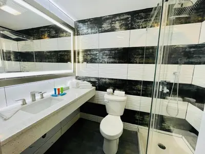 a bathroom with a toilet and a sink and a shower at Casa Azul Hotel Blu-UBS Arena in Queens