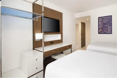 a white bedroom with a bed and a tv at Best Western Premier Empire State Hotel in New York