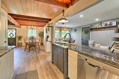 a kitchen with a large counter and a dining room at Deck and Pool Access Welcoming Poconos Retreat in Tobyhanna