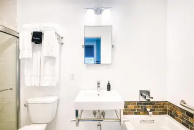 a white bathroom with a sink and a toilet at The Hudson Whaler in Hudson