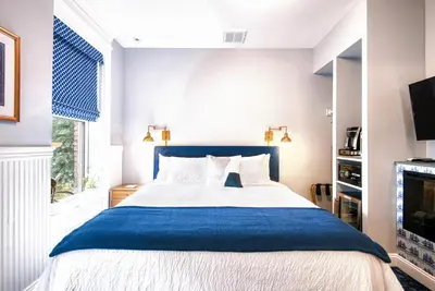 a bedroom with a blue and white bed and a tv at The Hudson Whaler in Hudson
