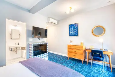 a bedroom with a bed and a desk and a fireplace at The Hudson Whaler in Hudson