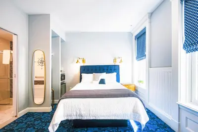 a bedroom with a large bed and a mirror at The Hudson Whaler in Hudson