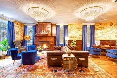 a living room with a couch and chairs and a fireplace at The Hudson Whaler in Hudson