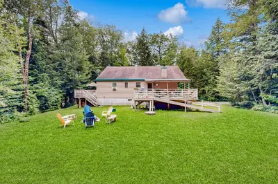 a house in the middle of a yard with chairs at Secluded Sanctuary in West Wardsboro